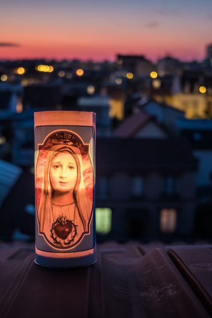 Une bougie représentant la Vierge Marie est allumée à Bois-Colombes (Hauts-de-Seine), le 25 mars 2020, à l'appel de l'Eglise catholique, en hommage aux victimes de l'épidémie, aux soignants et à ceux qui œuvrent pour la vie du pays. (CHRISTOPHE PETIT TESSON / MAXPPP)