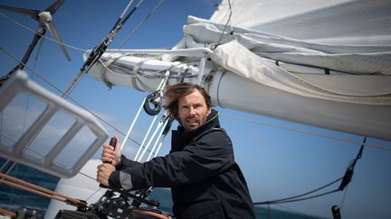 Le skipper français Romain Pilliard sur son trimaran,&nbsp; "Use it again", le long des côtes de la Trinité-sur-Mer, le 25 mai 2021. En 2016, il a décidé de retaper l'ancien trimaran de classe Ultim d'Ellen Mac Arthur, selon les principes de l'économie circulaire : Reduce, ReUse et Recycle.
 (LOIC VENANCE / AFP)