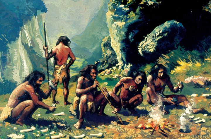 Un groupe d'Homo sapiens, regroupés autour d'un feu, taillent des outils en silex. Peinture de&nbsp;Francisco Fonollosa. (PrismaArchivo/Leemage)