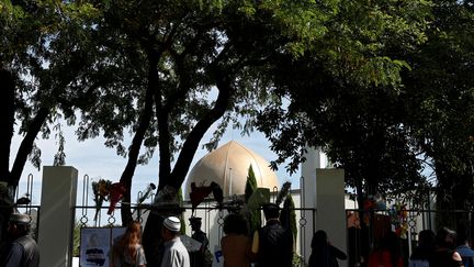 Des personnes réunies devant la mosquée al-Nour de Christchurch (Nouvelle-Zélande), frappée par un attentat, le jour de sa réouverture, le 23 mars 2019. (EDGAR SU / REUTERS)