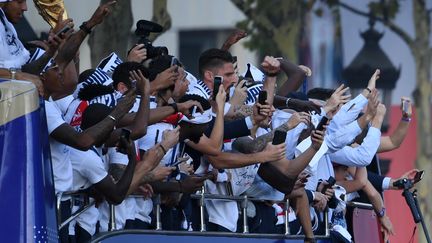 Les joueurs de l'équipe de France sur le toit du bus qui a descendu les Champs-Elysées pour fêter leur victoire en Coupe du Monde, le 16 juillet 2018. (ERIC FEFERBERG / POOL)