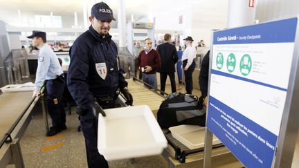 Des policiers remplacent les agents de s&ucirc;ret&eacute; gr&eacute;vistes &agrave; l'a&eacute;roport de Roissy, le 22 d&eacute;cembre 2011. (FRANCOIS GUILLOT / AFP)