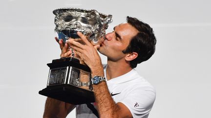 Roger Federer embrasse son trophée après avoir remporté&nbsp;son sixième Open d'Australie, le 28 janvier 2018 à Melbourne.&nbsp; (PAUL CROCK / AFP)