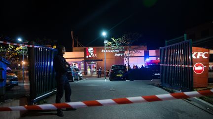 Des policiers enquêtent sur le parking d'un fast-food où deux hommes ont été trouvés morts par balle, à Marseille (Bouches-du-Rhône), le 21 octobre 2016. (BERTRAND LANGLOIS / AFP)