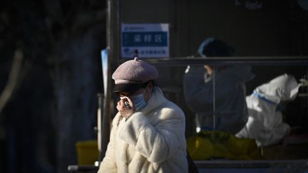 Une femme portant un masque après un test de dépistage du Covid-19 à Pékin (Chine), le 5 décembre 2022. (WANG ZHAO / AFP)