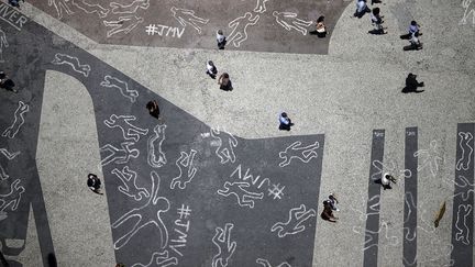 Des silhouettes dessin&eacute;es &agrave; la craie symbolisent les 4 000 personnes mortes &agrave; la suite de violence &agrave; Rio de Janeiro (Br&eacute;sil) en 2012, le 3 d&eacute;cembre 2013. (RICARDO MORAES / REUTERS)