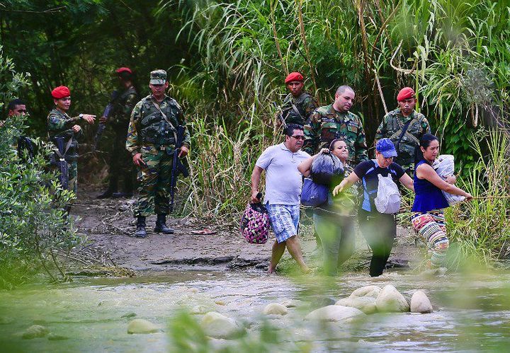 Des Colombiens quittent le Venezuela avec leurs affaires en passant par le fleuve Tachira, frontière naturelle entre les deux pays, le 26 août 2015. (LUIS ACOSTA / AFP)