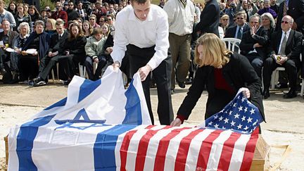 Des drapeaux isra&eacute;lien et am&eacute;ricain sont d&eacute;pos&eacute;s, le 9 mars 2003, &agrave; Ha&iuml;fa (Isra&euml;l), sur le cercueil d'une victime isra&eacute;lo-am&eacute;ricaine d'un attentat commis par un Palestinien. (RONI SCHUTZER / YEDIOTH AHARONOTH / AFP)