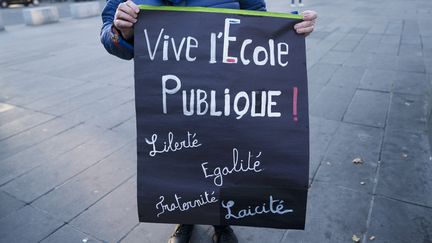 Une pancarte sur l'école publique lors d'une manifestation en hommage à Dominique Bernard, à Paris, le 17 octobre 2023. (FIORA GARENZI / HANS LUCAS / AFP)