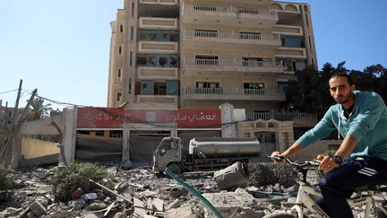 A man in a Gaza neighborhood partly destroyed by Israeli strikes, October 13, 2023 (RIZEK ABDELJAWAD / XINHUA)