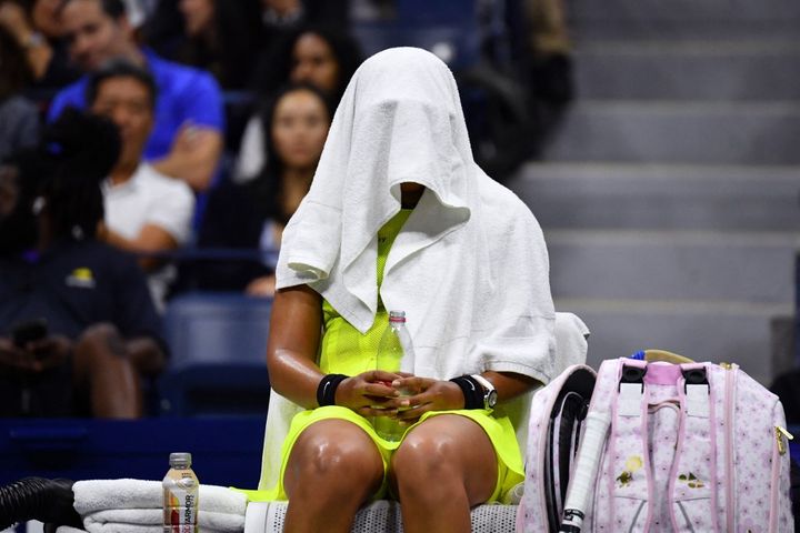 La tenniswoman japonaise Naomi Osaka, la tête cachée sous une serviette durant une rencontre de l'US Open, à New York (États-Unis), le 3 septembre 2021. (ED JONES / AFP)