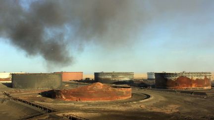 8 Janvier 2016: épaisse fumée provenant d'un réservoir de pétrole après un incendie au terminal pétrolier Al-Sidra, près de Ras Lanouf, le long de la côte Nord de la Libye. La zone pétrolière est disputée entre les deux pouvoirs, celui de l'Est et celui de l'Ouest. (STRINGER / AFP)