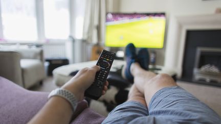 Une personne regarde un match de football à la télévision. Image d'illustration. (CAIA IMAGE / COLLECTION MIX: SUBJECTS RF)