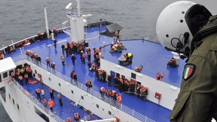 Transis de froid, les passagers ont &eacute;t&eacute; h&eacute;litreuill&eacute;s un &agrave; un par les &eacute;quipes de secours de l'arm&eacute;e italienne. (MARINA MILITERE / REUTERS)