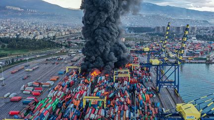 Un énorme incendie qui s'est propagé à des dizaines de conteneurs brûle dans le port turc d'Iskenderun, après un violent séisme, le 7 février 2023. (HANDOUT / DHA / AFP)