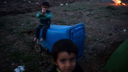 D'après les estimations, sur les 13 000 personnes que compte le camp, 34% seraient des enfants. Deux d'entre eux tentent de passer le temps, le 8 mars 2016. (KONSTANTINOS TSAKALIDIS / SOOC)