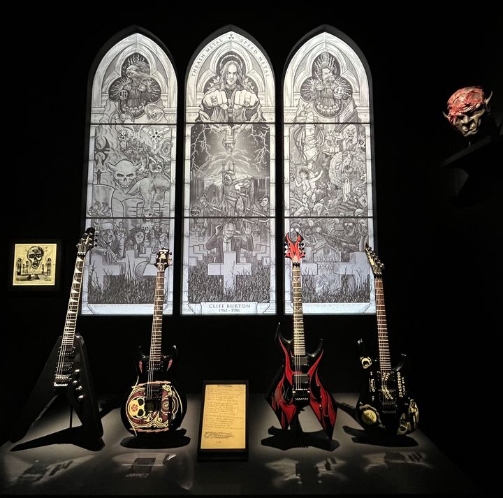 Quelques guitares de légende (ayant appartenues de gauche à droite à Dave Mustaine de Megadeth, Scott Ian d'Anthrax, Kerry King de Slayer et Kirk Hammett de Metallica) dans la "chapelle" Speed et Trash Metal, à l'exposition "Metal, Diabolus in musica" à la Philharmonie de Paris, avril 2024. (LAURE NARLIAN / FRANCEINFO)