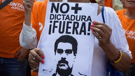 Une manifestante tient une affiche où il est écrit «Plus jamais de dictature!», à Caracas (Venezuela), le 1er avril 2017 dans le cadre d'une manifestation contre la décision de la Cour suprême de s'arroger les pouvoirs de l'Assemblée. La juridiction reviendra sur sa décision quelques heures plus tard. (CITIZENSIDE / ANDREA HERNANDEZ / CITIZENSIDE)