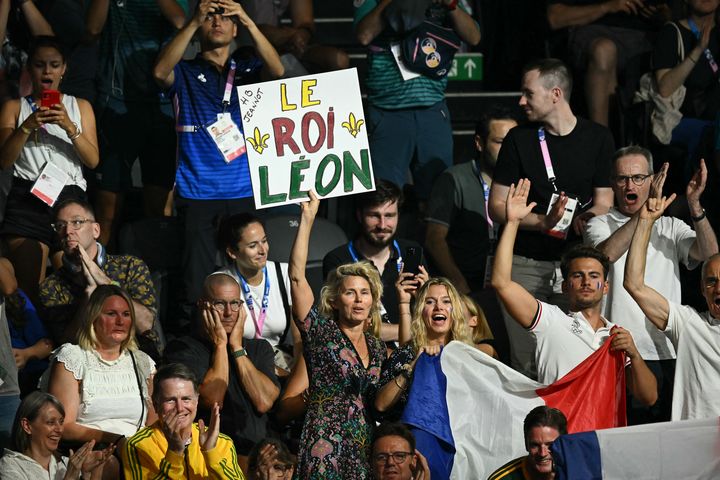 Les supporters de Léon Marchand applaudissent le Français lors de la finale du 200 m brasse masculin lors des Jeux Olympiques de Paris 2024 à la Paris La Défense Arena, le 31 juillet 2024, à Nanterre. (SEBASTIEN BOZON / AFP)