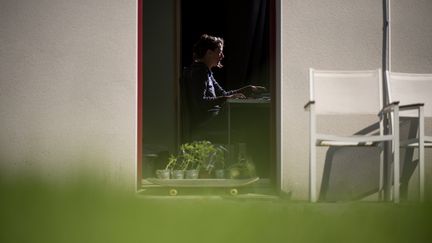 Une femme travaille depuis chez elle pendant le confinement, à Nantes, en mai 2020. (LOIC VENANCE / AFP)