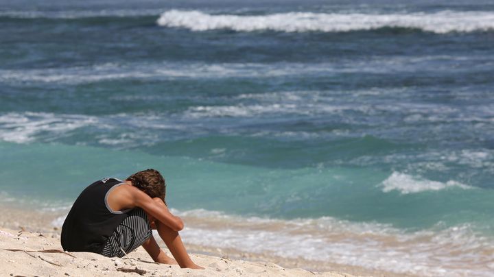Un jeune homme sur la plage o&ugrave; a eu lieu l'attaque mortelle de requin &agrave; Saint-Gilles (La R&eacute;union), le 8 mai 2013. (RICHARD BOUHET / AFP)