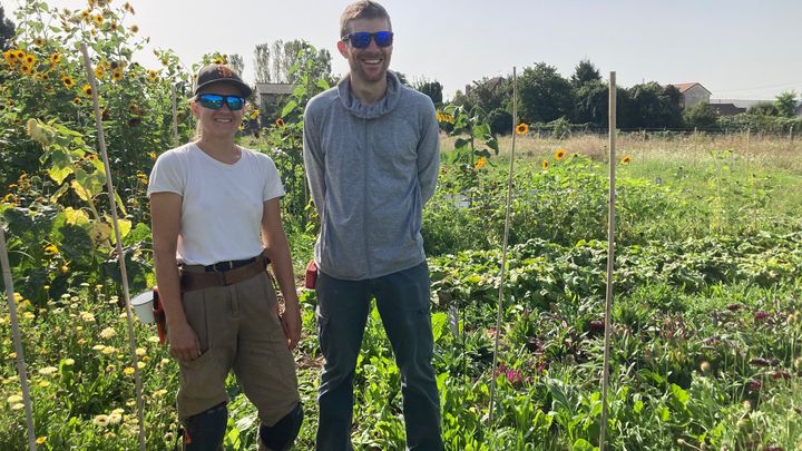 Félix Romain et l'une des membres de son équipe dans sa ferme florale urbaine, à Vitry-sur-Seine (94). (INGRID POHU / RADIOFRANCE)