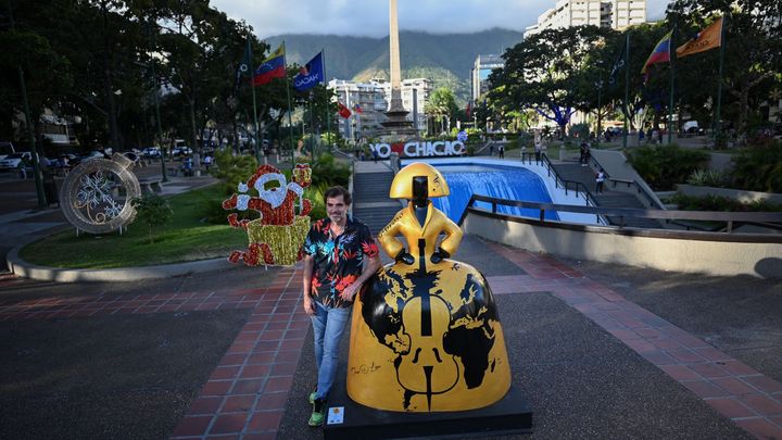 L'artiste vénézuélien Antonio Azzato pose à côté de l'une de ses sculptures qui font partie de l'exposition de rue "Meninas Caracas Gallery", qui rend hommage à "Las Meninas" de l'artiste espagnol Diego Vélasquez, à Caracas, le 10 janvier 2024. (FEDERICO PARRA / AFP)