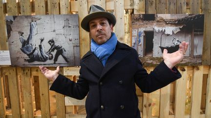 François Bérardino devant des œuvres de l'exposition BMC (Banksy Modest Collection), à Libourne (Gironde), le 26 avril 2023. (MEHDI FEDOUACH / AFP)