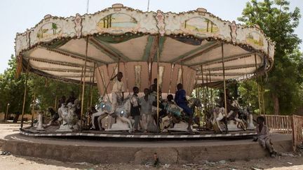 Rendus orphelins par les attaques de Boko Haram, des enfants nigérians s'amusent avec le manège d'un parc d'attraction abandonné de Maiduguri, le 27 avril 2017. Depuis l'apparition du groupe djihadiste, la population de cette ville a doublé, passant à deux millions de personnes, dont des milliers d'enfants sans domicile. (Florian PLAUCHEUR / AFP)