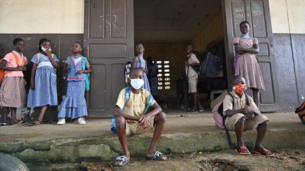 Des enfants devant leur classe dans une école primaire à Attecoube, quartier populaire d'Abidjan, le 25 mai 2020, premier jour de la reprise des cours après le confinement lié au coronavirus. (ISSOUF SANOGO / AFP)