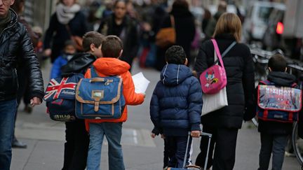 Des enfants vont à l'école à Paris, le 16 novembre 2015, trois jours après les attentats dans la capitale. (KENZO TRIBOUILLARD / AFP)