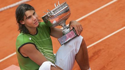 A tout juste 19 ans, Rafael Nadal remporte son premier trophée&nbsp;à&nbsp;Roland-Garros - et son premier Grand Chelem -, le 5 juin 2005, face à l'Argentin Mariano Puerta (6-7, 6-3, 6-1, 7-5). Le début d'une longue série. (CHRISTOPHE SIMON / AFP)