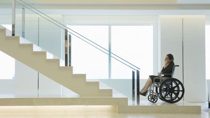 Une femme handicap&eacute;e regarde les escaliers non &eacute;quip&eacute;s d'une rampe pouvant lui permettre de monter.&nbsp; (HUNTSTOCK / GETTY IMAGES )