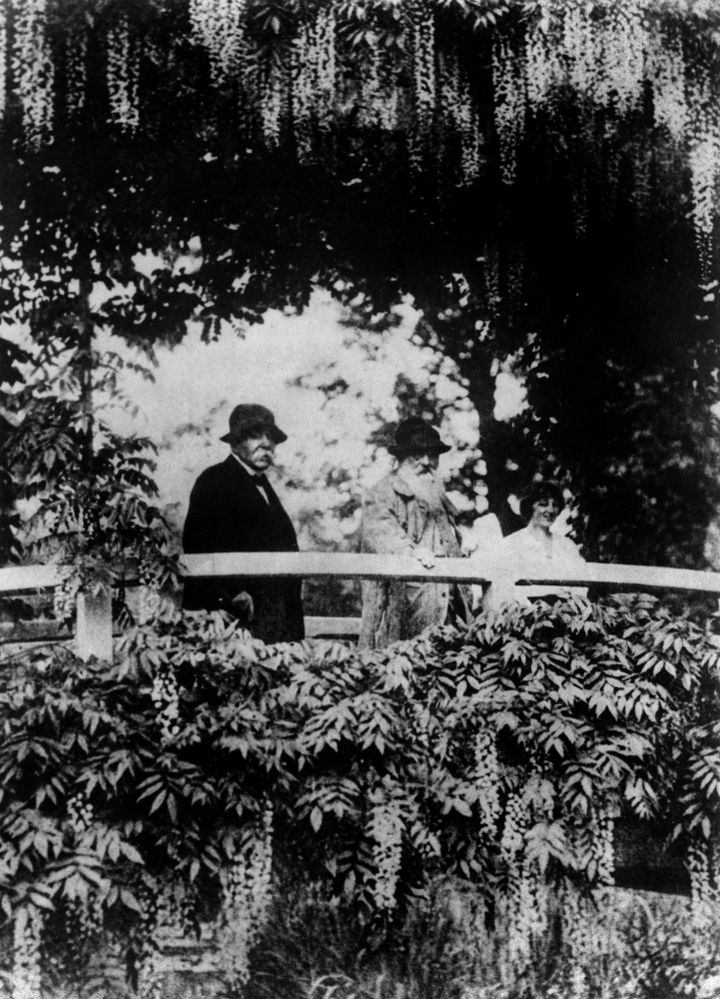 Photo prise au mois de juin 1921 à Giverny de l'ancien président du Conseil Georges Clémenceau (G), avec le peintre Claude Monet et la dessinatrice de mode Lily Butler passant sur le pont japonais de la propriété de Monet. 
 (SAMJI KUROKI / FRANCE PRESSE VOIR / AFP)