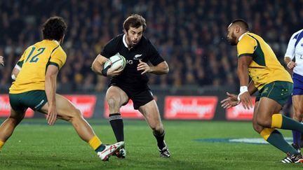 Le All Black Conrad Smith tente de passer entre les deux Walabies, Matt Tomua et Sekope Kepu (MICHAEL BRADLEY / AFP)