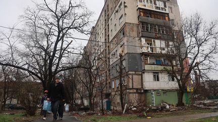 Deux personnes marchent à Marioupol (Ukraine), le 13 avril 2022. (LEON KLEIN / ANADOLU AGENCY / AFP)