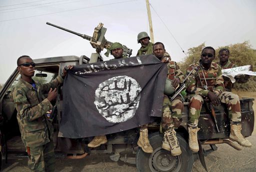 Des militaires nigérians brandissent, le 23 août 2016, un drapeau de Boko Haram saisi dans la ville de Damasak (à la frontière avec le Niger), reprise en 2015 au groupe djihadiste. (REUTERS/Emmanuel Braun/File Photo)