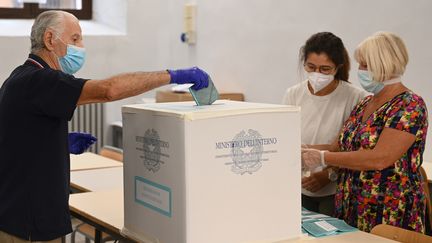 Un Italien dépose son bulletin dans l'urne, pour le référendum sur le nombre de parlementaires, dans un bureau de vote du centre de Rome, le 20 septembre 2020 (photo d'illustration). (VINCENZO PINTO / AFP)