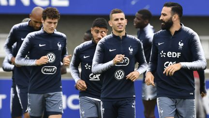 Benjamin Pavard (à gauche) emporte avec lui... des shampoings ! Pour Adil Rami (à droite), pas question d'oublier sa Playstation. (GERARD JULIEN / AFP)