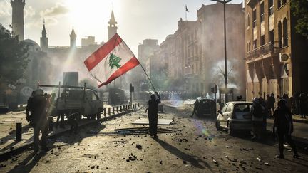 Un manifestant porte un drapeau du Liban à Beyrouth, le 9 août 2020. (NURPHOTO/AFP)