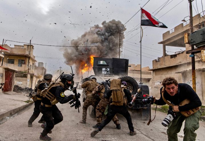 Iraq, 2016. A suicide car explodes ahead of a column of the Golden Division advancing through Mosul against the Islamic State.  In the foreground, Antoine Chauvel, son of Patrick.  (PATRICK CHAUVEL)