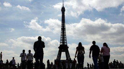 Des touristes admirent la tour Eiffel, le 13 juillet 2007 &agrave; Paris. (CLEMENS BILAN / AFP)