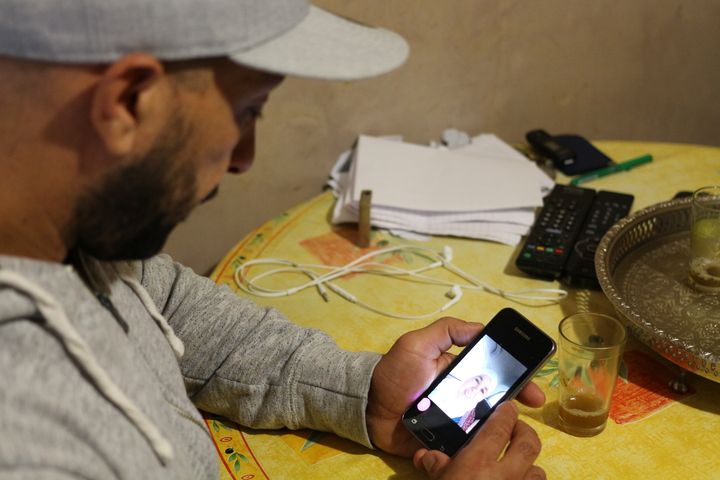 Ali Charrihi regardant une photo de sa mère, Fatima, sur son téléphone portable, le 13 octobre 2016 à Nice (Alpes-Maritimes). (BENOIT ZAGDOUN / FRANCEINFO)