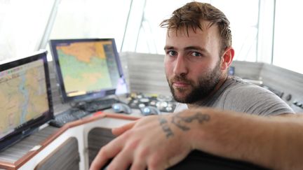 Matthieu Claquin, patron du fileyeur "Noz Dei II", pose dans la cabine de son bateau, le 14 février 2024, à Audierne (Finistère). (YANN THOMPSON / FRANCEINFO)