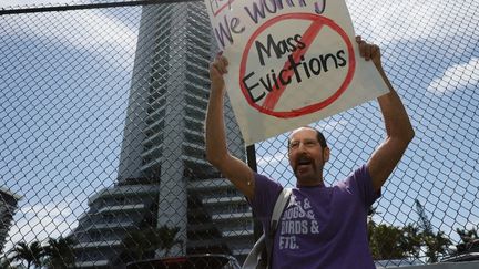 Un homme proteste contre les&nbsp;avis d'expulsion, devant un immeuble à Miami (Floride, Etats-Unis), le 8 juin 2021. (JOE RAEDLE / GETTY IMAGES NORTH AMERICA / AFP)