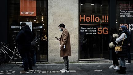 Des personnes font la queue devant une boutique Orange, le 23 février 2021.&nbsp; (PHILIPPE LOPEZ / AFP)