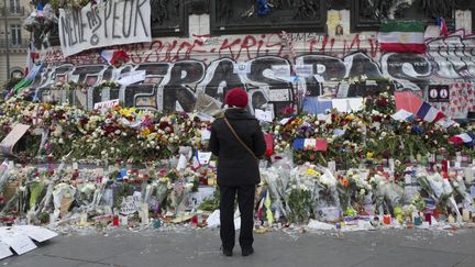 Une femme se recueille devant la statue de la place de la République, le 27 novembre 2015, deux semaines après les attentats de Paris.&nbsp; (CAROLINE PAUX / CITIZENSIDE.COM / AFP)