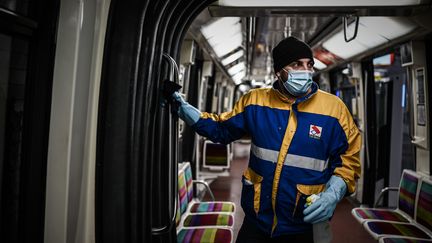 Un nettoyeur&nbsp;porte un masque et des gants pour désinfecter le métro à Vincennes, près de Paris. (PHILIPPE LOPEZ / AFP)