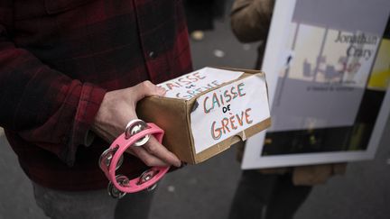 Un manifestant tient une caisse de grève lors de la manifestation contre la réforme des retraites du 11 mars 2023 à Paris. (LAURE BOYER / HANS LUCAS / AFP)