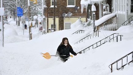 Une habitante d'Erie (Etats-Unis) déneige l'accès à sa maison, le 26 décembre 2017. (GREG WOHLFORD/AP/SIPA / AP)